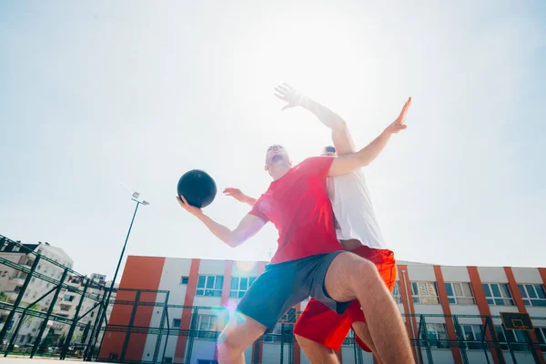 Dos jugadores de baloncesto machos fuertes juegan al aire libre peleando —  Fotos de Stock