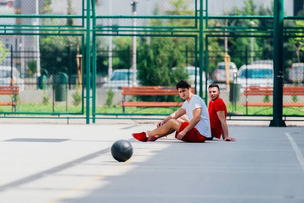 長いハードバスケットボールの試合の後の2人の友人は、いくつかの休息を持っています — ストック写真