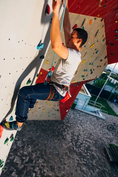 Hombre deportivo colgando pared de escalada de deporte extremo en gimnasio al aire libre —  Fotos de Stock