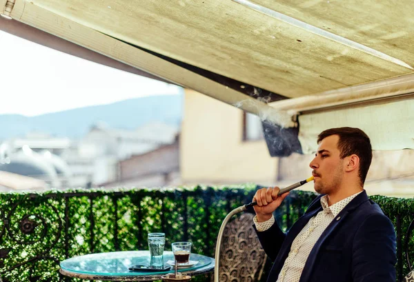Städtischer Geschäftsmann entspannt sich nach Feierabend und raucht Pfeife — Stockfoto