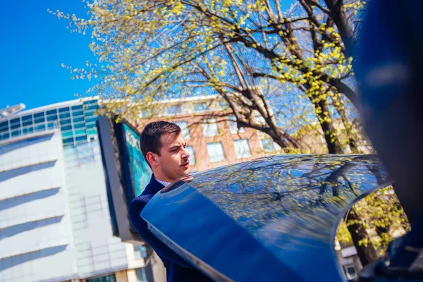 Ein gutaussehender Geschäftsmann mit blauem Blazer, der die Kapuze hochzieht — Stockfoto