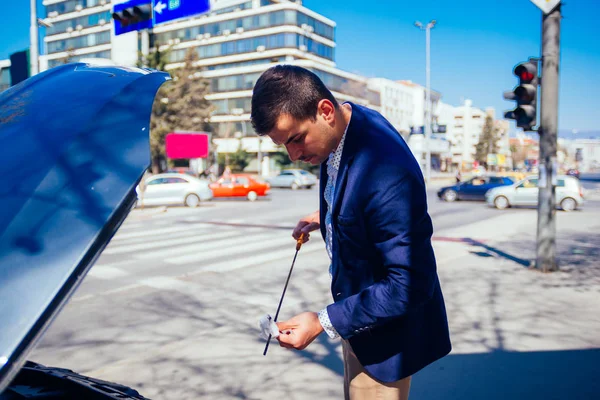 Um homem de negócios bonito vestindo blazer azul levantando o capô o — Fotografia de Stock