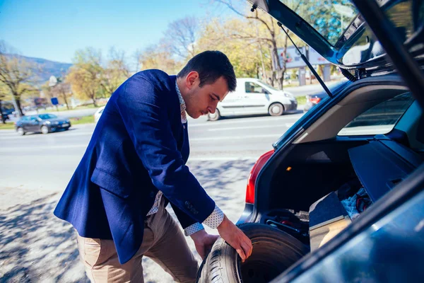 A fáradt üzletember egy napsütéses napon vesz egy gumiabroncs-ből a c — Stock Fotó