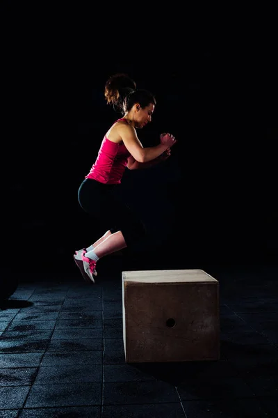 适合女人正在执行在健身房跳箱子 — 图库照片