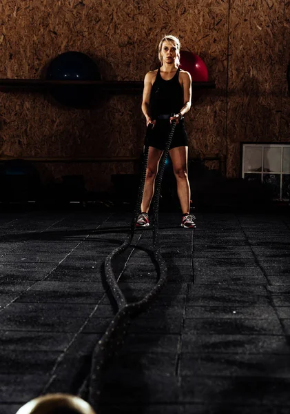Молода жінка робить кросфіт тренування з мотузками — стокове фото
