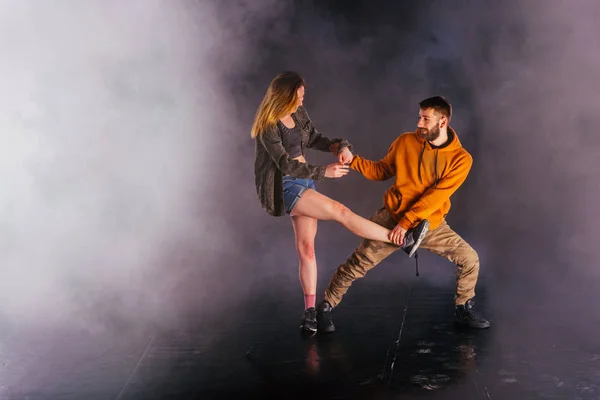 Couple dancing modern dance and showing off their leg stretch mo