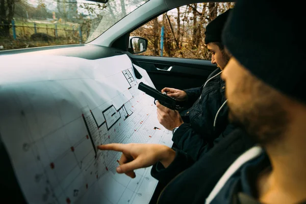 Két fegyveres bandita ül egy kocsiban, és a következő rablást tervezik., — Stock Fotó