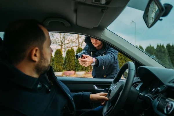 Armed bandit hijacking a middle-aged man's car. — Stock Photo, Image