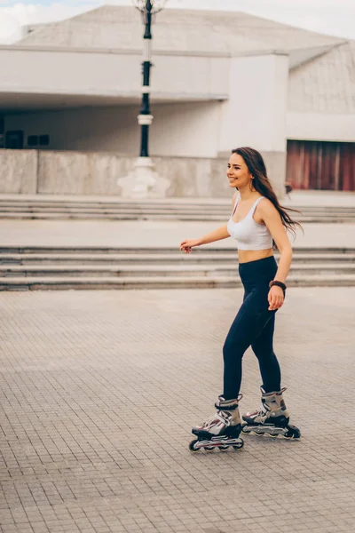 Весела дівчина на роликових ковзанах у променях заходу сонця — стокове фото