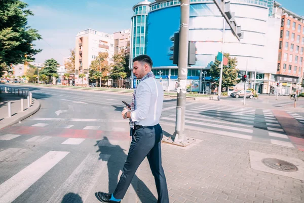 Junge moderne Geschäftsmann ist draußen, zu Fuß in der Stadt, während l — Stockfoto