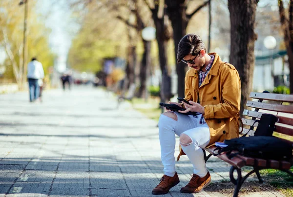 Αστικός επιχειρηματίας εργάζονται σε tablet, ενώ κάθονται σε πάγκο στο p — Φωτογραφία Αρχείου