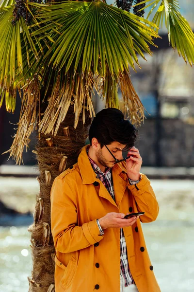 Attraente uomo d'affari guardando sul suo dispositivo mobile — Foto Stock