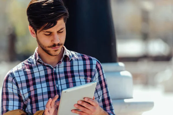 Homme d'affaires avec manteau en utilisant une tablette en milieu urbain — Photo