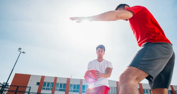 Due giocatori caucasici di basket che lottano per il possesso palla a — Foto Stock