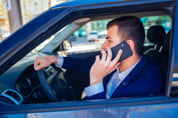 Empresario hablando por teléfono mientras conduce su coche de la ciudad en t — Foto de Stock