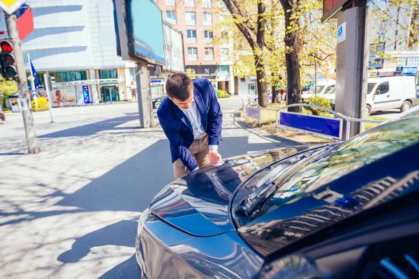 En snygg affärsman klädd i blå kavaj lyfta upp huven o — Stockfoto