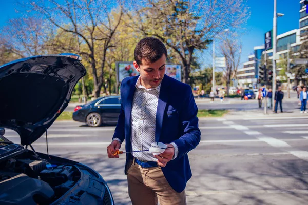 Egy jóképű üzletember visel kék bletter emelés fel a motorháztető o — Stock Fotó