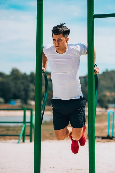 Fit Male doen triceps dips op metalen staven in City Park — Stockfoto