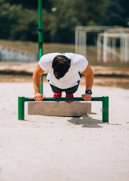 Muskulös idrottsman utövar driva upp utanför i Sunny Park — Stockfoto