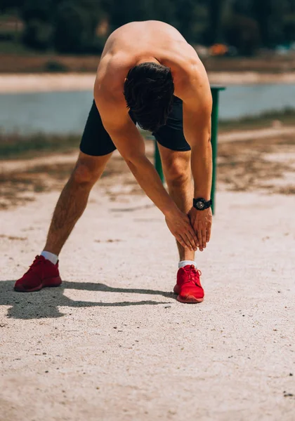 Jonge man training op strand buiten — Stockfoto