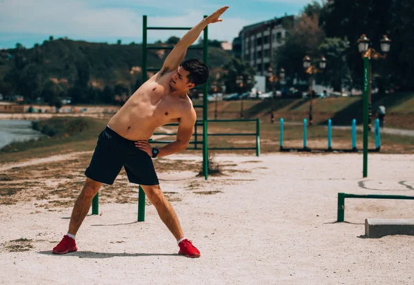 Портрет фитнесмена, делающего упражнения на растяжку в спортзале — стоковое фото