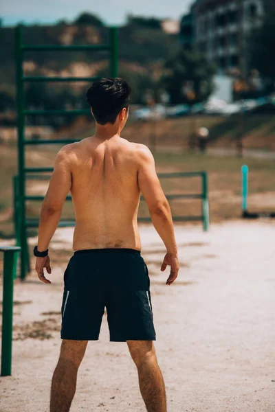 Fit man warming-up voor het lopen op het strand — Stockfoto
