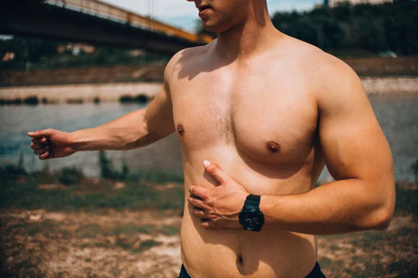 Молодой человек без спортивной рубашки на открытом воздухе у реки или ручья — стоковое фото