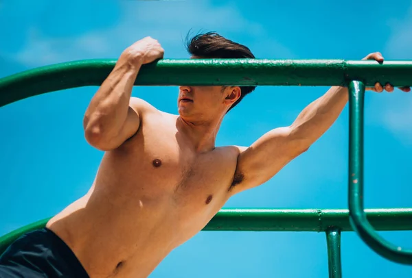 Shirtless man gör triceps dips på parallella barer — Stockfoto