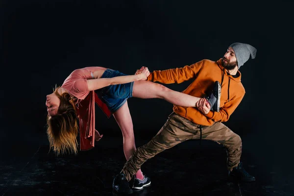 Couple dancing modern dance and showing off their leg stretch mo