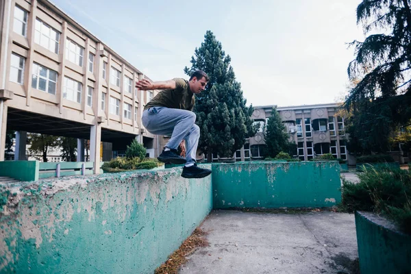 Strongman tijdens het trainen Parkour springen over de betonnen muur — Stockfoto