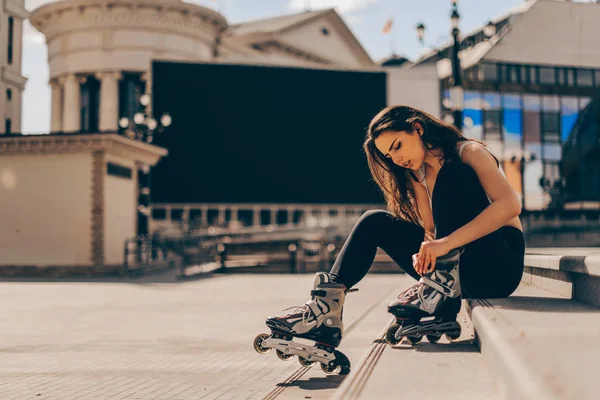Жінка, що катається на роликах, одягає вбудовані ковзани для катання на роликах — стокове фото