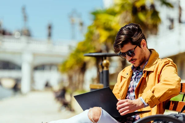 Giovane uomo d'affari lavoro sul computer portatile seduto sulla panchina — Foto Stock