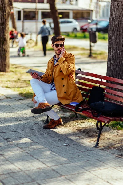 Uomo elegante in cappotto giallo agghiacciante nel parco — Foto Stock