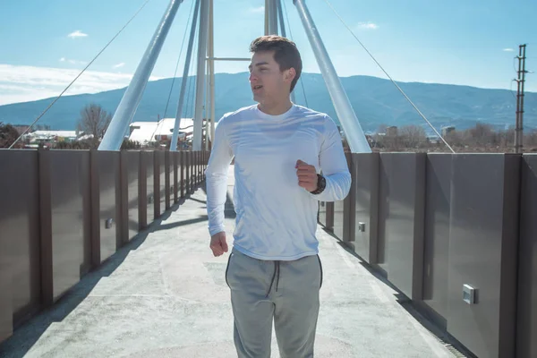 穿着运动服的运动衣穿过桥的运动型男子 — 图库照片