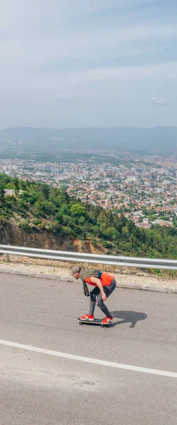 Hombre hipster usando un sombrero y una camisa roja está montando un longboard —  Fotos de Stock