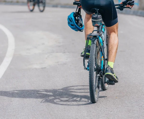 Sportovní cyklista jezdí na kole do kopce, na sobě profesionální cyklistika — Stock fotografie