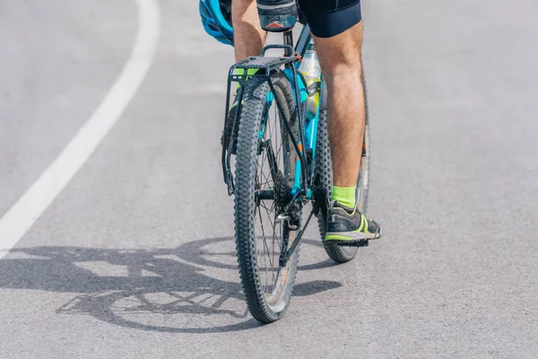 Atleet biker rijdt zijn fiets bergop, het dragen van professionele fietsen — Stockfoto