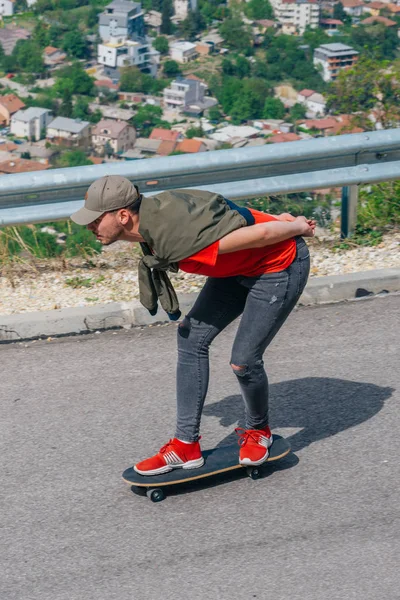 Lång passform hane rida en longboard på en öppen väg medan performin — Stockfoto