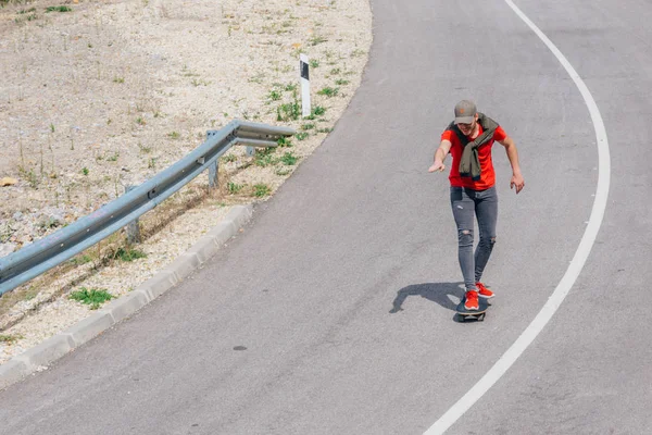 Muž kavkazský longboardista sjíždějící z kopce po prázdné silnici, před — Stock fotografie