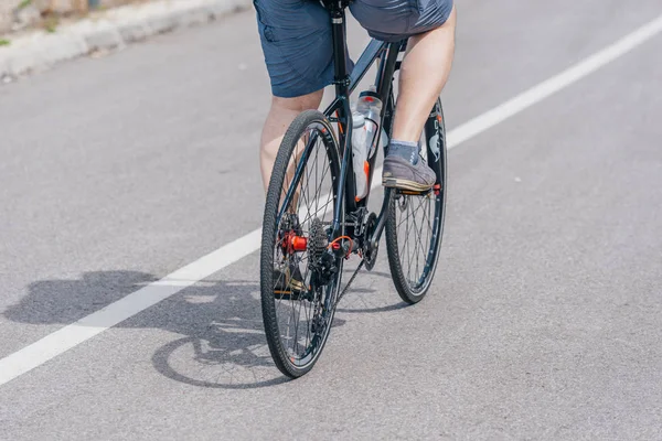 Un motociclista caucasico di sesso maschile guida la sua moto in salita, indossando professione — Foto Stock