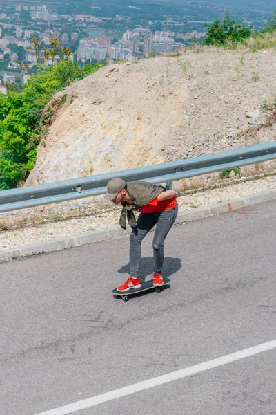 Lång passform hane rida en longboard på en öppen väg medan performin — Stockfoto