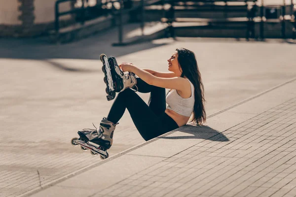 Міська дівчина зав'язує мережива на вбудованих ковзанах — стокове фото