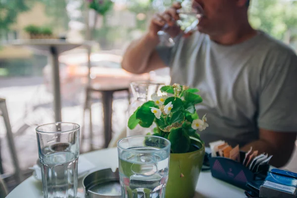 天気の良い日におしゃべりしながら喫茶店でコーヒーを飲んでいる老人と若い紳士 — ストック写真