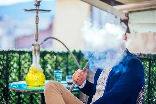 Un empresario guapo con pelo facial fumando shisha (nargile ) —  Fotos de Stock