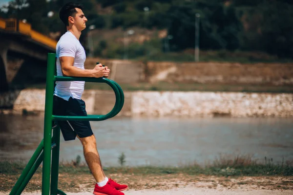 Gespierde man doet abdominale oefening op rekstok — Stockfoto