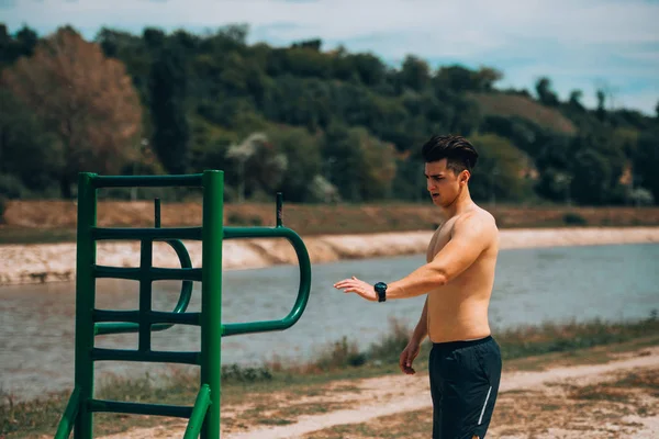 Atraente atlético homem exercício no verão parque ao ar livre — Fotografia de Stock