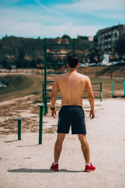 Geconcentreerde atletische man die buitenshuis opwarmt — Stockfoto