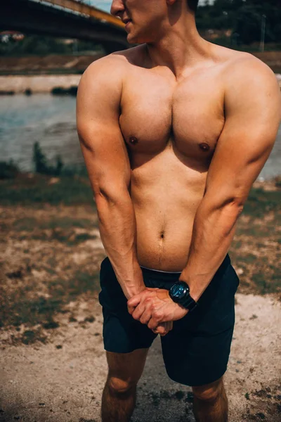 Bonito homem muscular posando na natureza — Fotografia de Stock