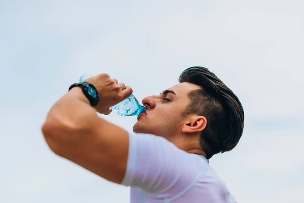 Deportivo caucásico hombre beber agua después crossfit entrenamiento — Foto de Stock