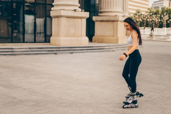 Молода дівчина підходить на роликових ковзанах, катаючись на відкритому повітрі — стокове фото